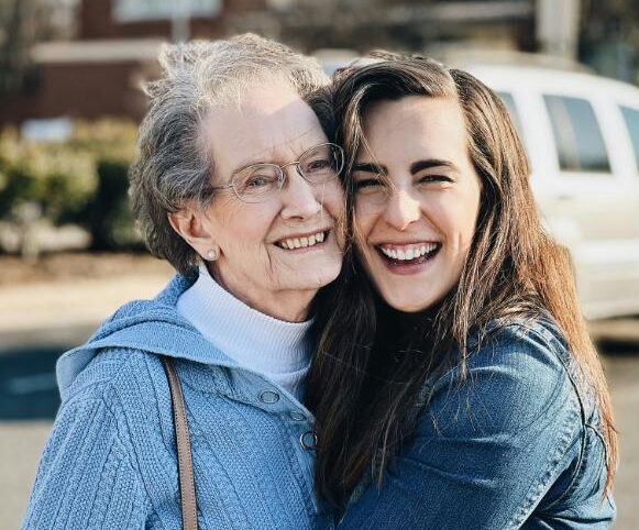 gran and granddaughter hugging and smiling outside