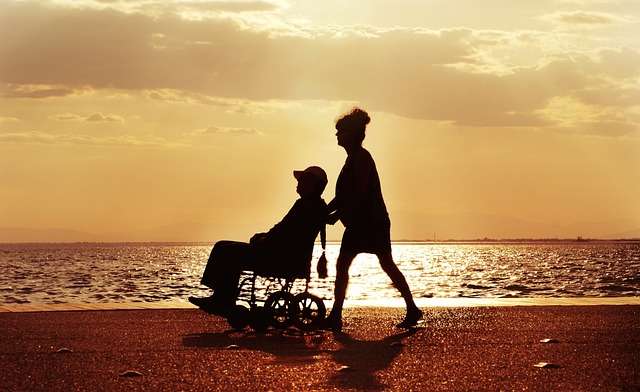 caregiver pushing a wheelchair user