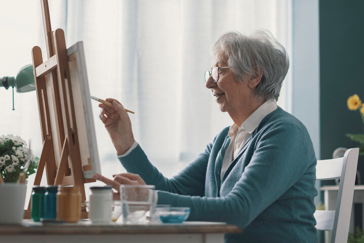 old woman painting at a care home